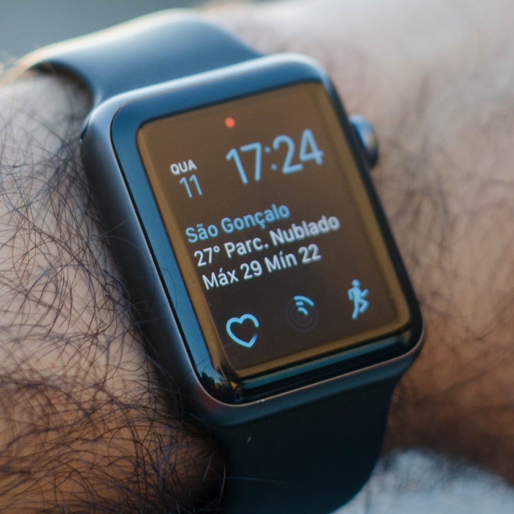 Smartwatch on a wrist displaying weather information and time.