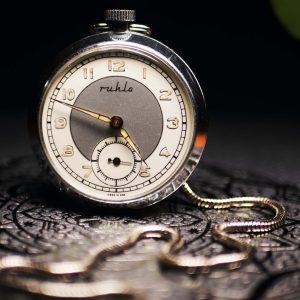 Vintage pocket watch with chain on a dark background