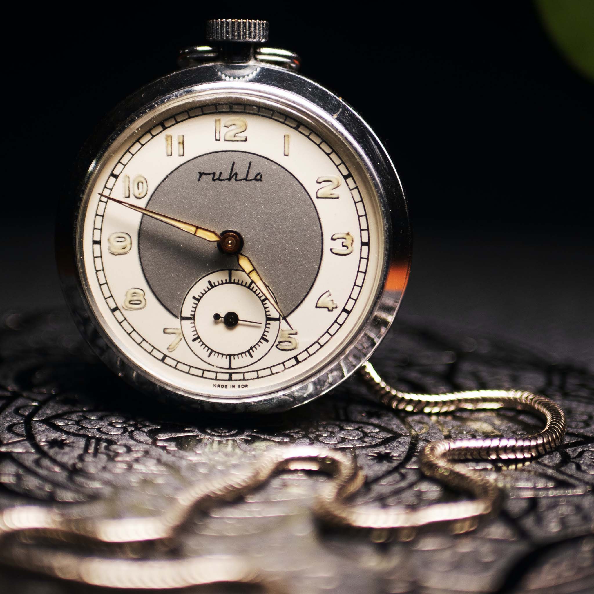 Vintage pocket watch with chain on a dark background