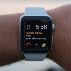 Smartwatch on a wrist displaying time and location information.