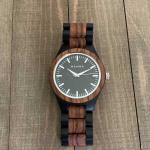 Wooden watch with black strap on a wooden surface