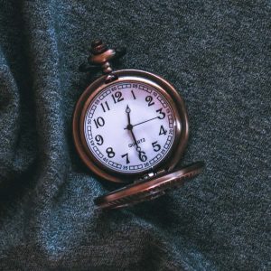 Vintage pocket watch on a textured green surfacev