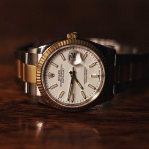 Luxury watch with gold and silver case on a wooden surface